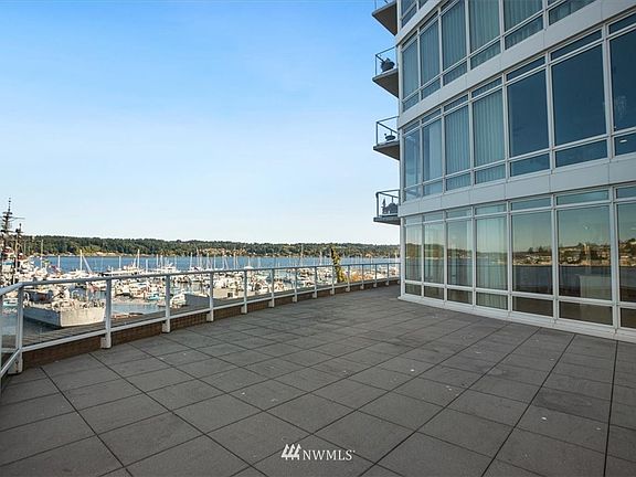 The patio on the north side of the condo has a wonderful view of the waterway, marina and Manette.  This photo gives you a good view of the floor to ceiling windows that make up the outside wall of the condo.  There iis access to the patio from the living romm and the master bedroom.   You can place your own planters in this deck area.