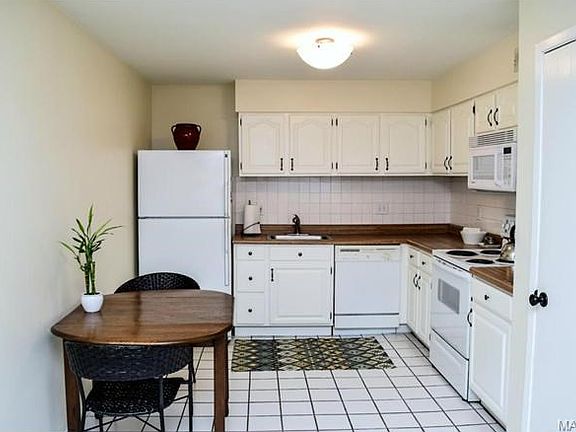 Updated neutral kitchen with tile floor and pantry.
