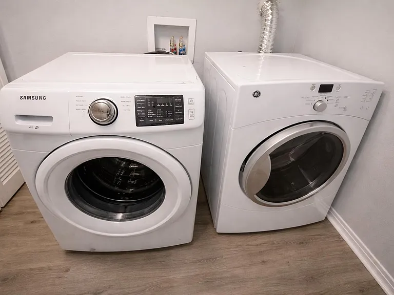 Dedicated laundry area with full-size front-load washer and dryer, offering convenient in-home laundry and easy access.