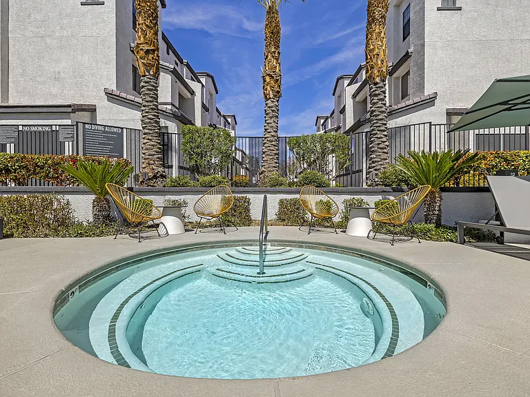 The Michael B's luxury apartment complex boasts a tranquil jacuzzi retreat, surrounded by lush palm trees and sleek architectural marvels. Dive into serenity amidst the cityscape.