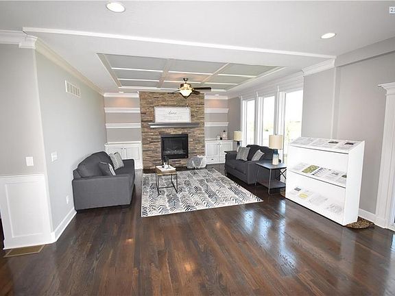 Spacious Great Room, All Hardwood Floors, Builtin Cabinets and Floating Shelves.  Note the Ceiling Trim, this home is LOADED with Quality Upgrades.  Former Model Home.  Note the Crown Moulding on top left, this builder put TONS of Extras, Trim Package is Exceptional
