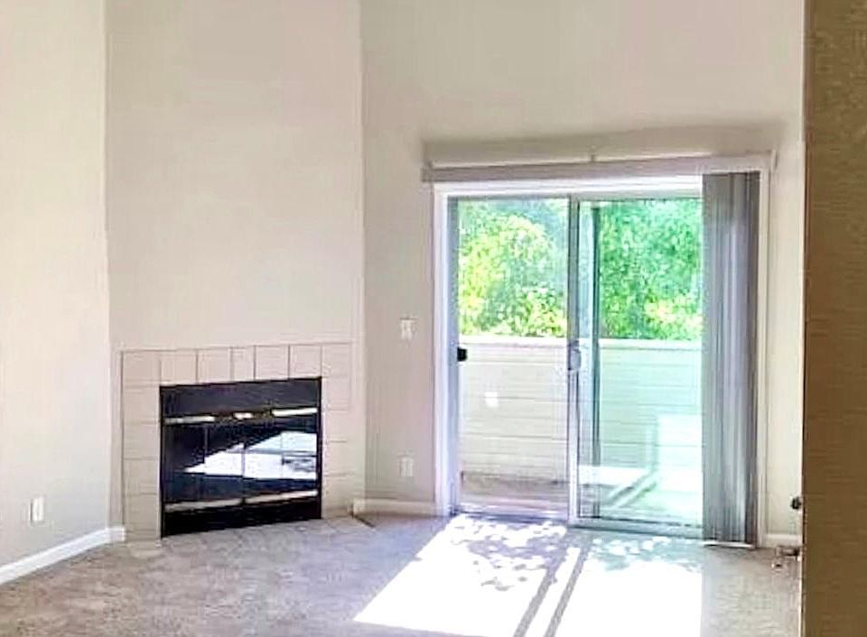 Living Room. Fireplace. Cathedral ceiling. Patio overlooking cherry blossom trees & pool.