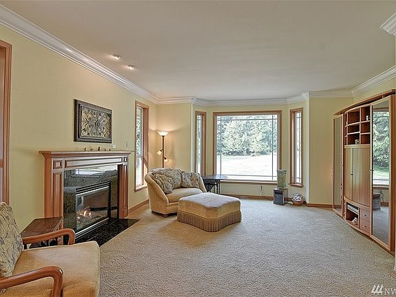 Warm up by the fireplace enjoying a warm cup of your favorite beverage while the evening light pours in. Check out the crown molding and large windows!  