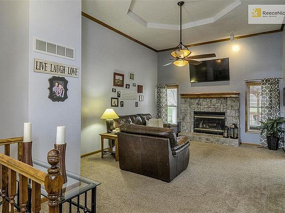 SPACIOUS LIVING ROOM, ATTRACTIVE STONE FIREPLACE AND CEILING FAN