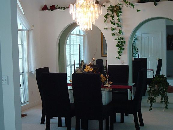 Open dining room with arches over mirrored wall.