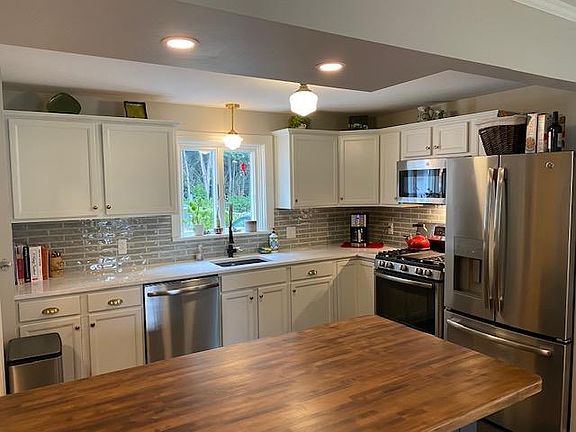 Quartz countertops and island open to eating area