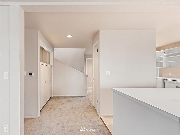 Another photo looking towards the entry with kitchen to the right. Hallway to the left leads to main floor bathroom.
