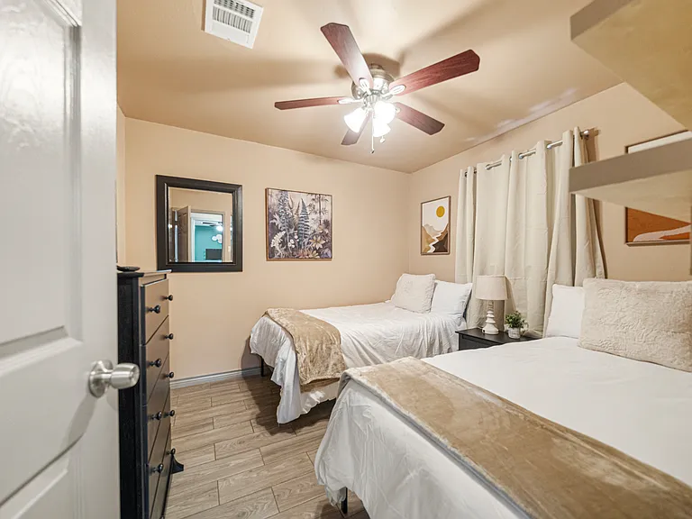 Room with 2 twin beds, dresser and 32" TV.