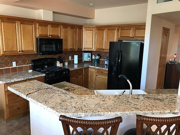 Kitchen area with granite countertops and bar seating.