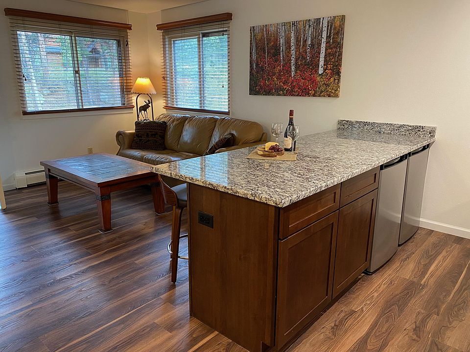 Generous granite kitchen counter looking into living room - shows part of the renovation. Flooring, kitchen cabinets, sink and granite countertop are all new. Old photos pre-renovation are included in this listing.