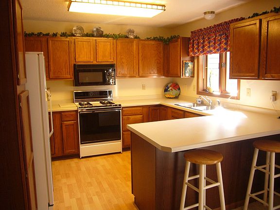 This large kitchen is spotless and features pergo floors and lots of cabinets.