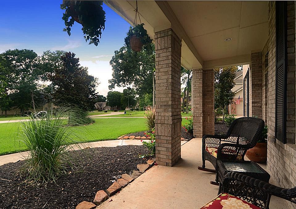 A lovely walkway leads to this covered front Porch that is accentuated with massed brick columns and views down a quiet road