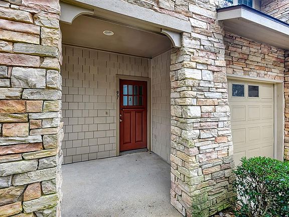 The covered front porch is spacious and enjoys some privacy from the street with trees in front of the home.