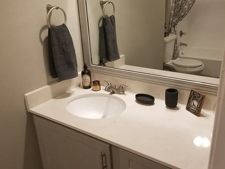 Oakwood Creek Apartments bathroom sink, mirror, and counter with cabinets