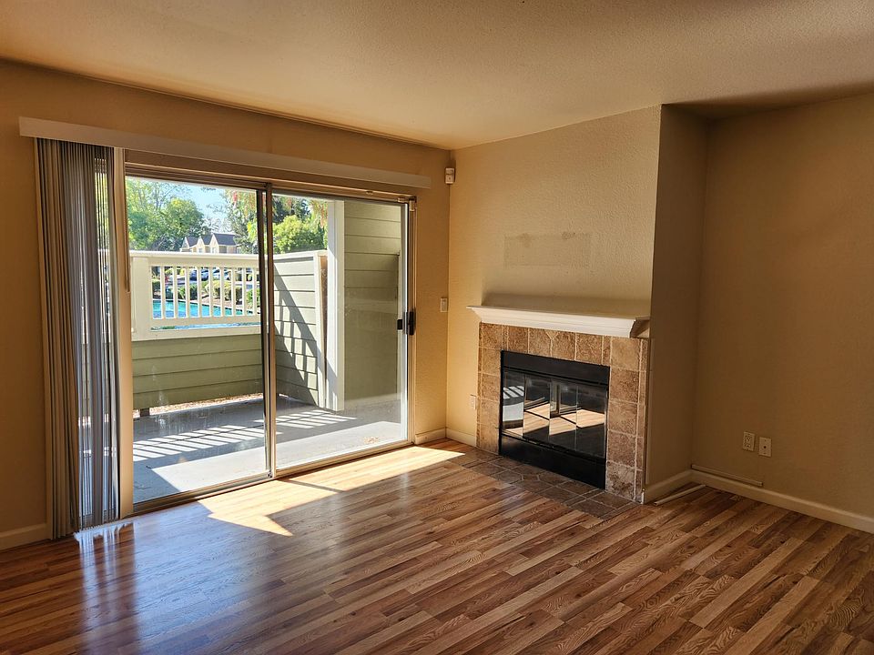 Living area with fireplace, patio with sliding door overlooking fountains