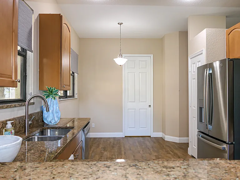 View of Kitchen thru Dining Room pass thru. Door to Laundry Room beyond