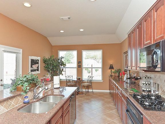 View of kitchen looking into the large breakfast area. Tons of cabinets.