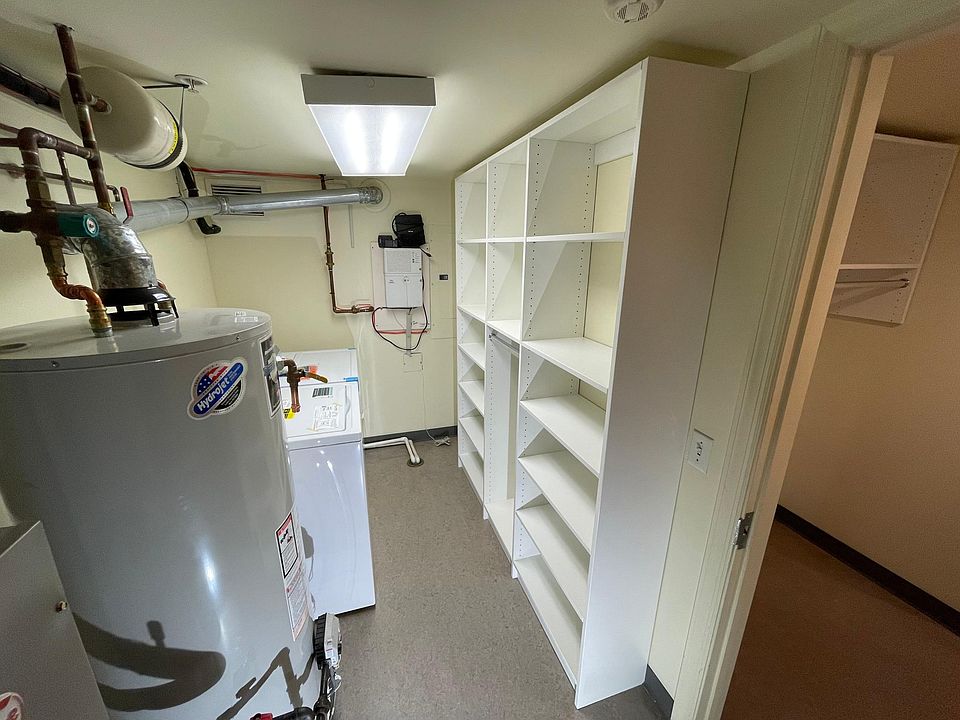 Laundry room with full size washer/dryer and storage.