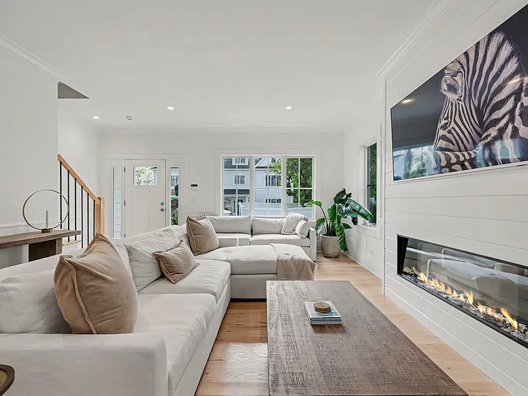A stylish living room anchored by a gas fireplace, creating a warm, polished backdrop for relaxing, hosting, and enjoying the home's refined coastal aesthetic.