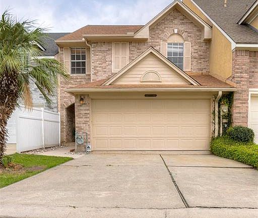A view of the townhome as you pull into the double car driveway and garage.