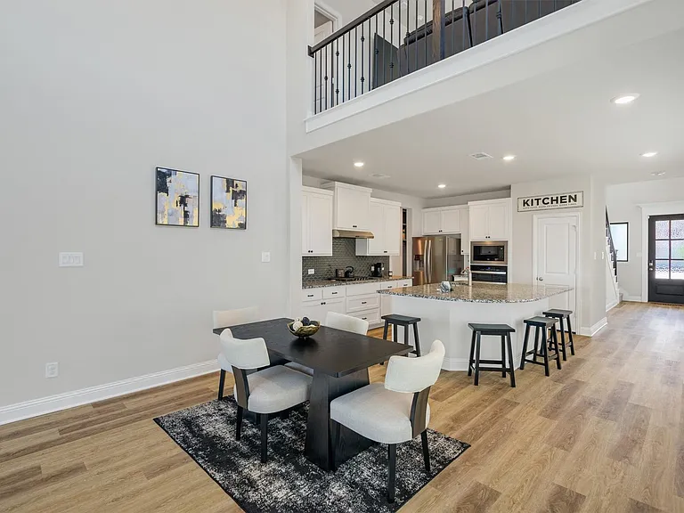 Open-concept living space featuring high ceilings and wood-finish flooring