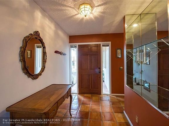 As you enter foyer entry you look out to living room and dome screened patio