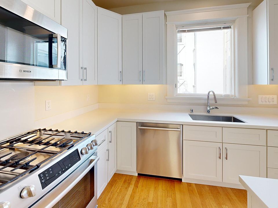 Kitchen with multiple cabinets, stove, and sink