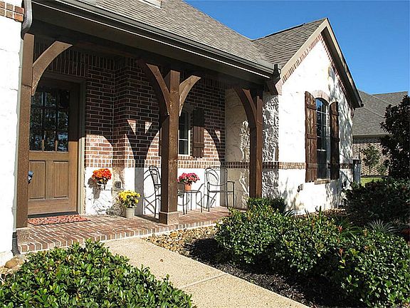 Extensive landscaping, covered front porch, & stone accents compliment this home's manicured exterior.
