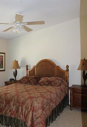 Second bedroom has queen sized bed and overhead fan.
