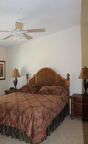 Second bedroom has queen sized bed and overhead fan.