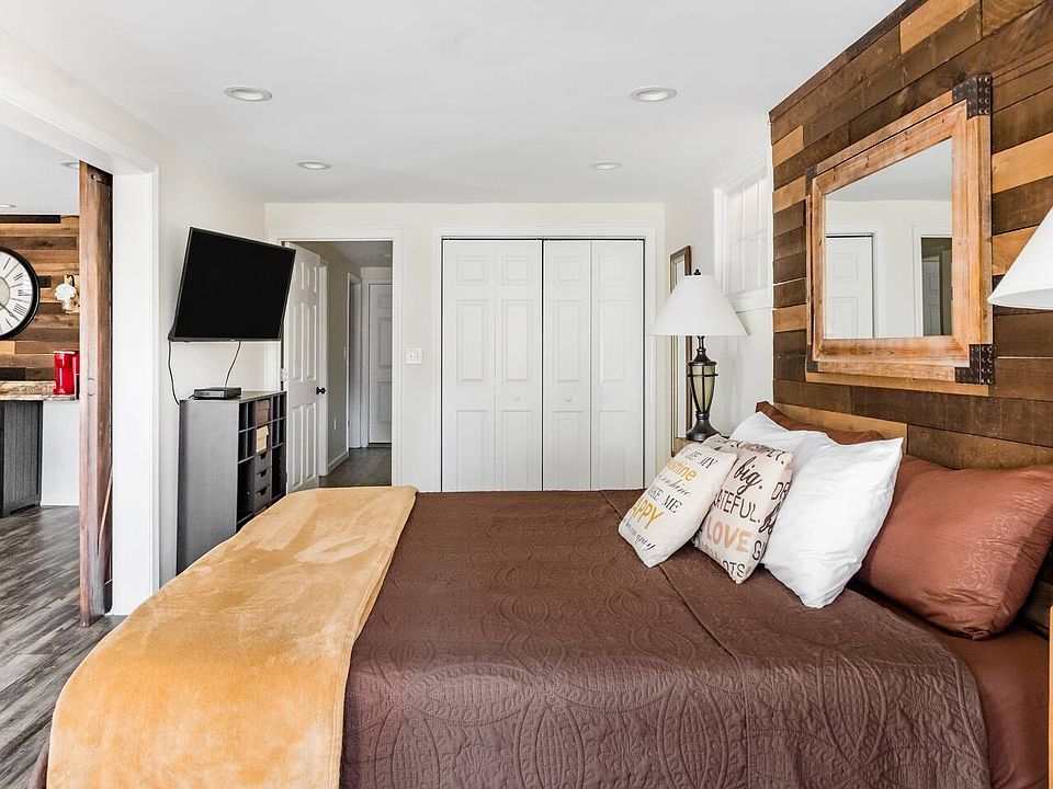 This spacious fifth bedroom also features a wall-mounted TV, a full-sized closet for ample storage, and direct walkout access perfect for savoring serene mornings and stunning sunrise views.