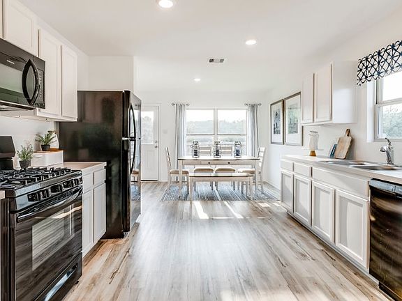 The spacious kitchen boasts a complete set of brand-new appliances and stylish flooring. An ample su