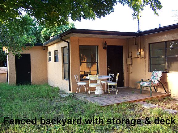 Back of house, fenced yard with deck and storage