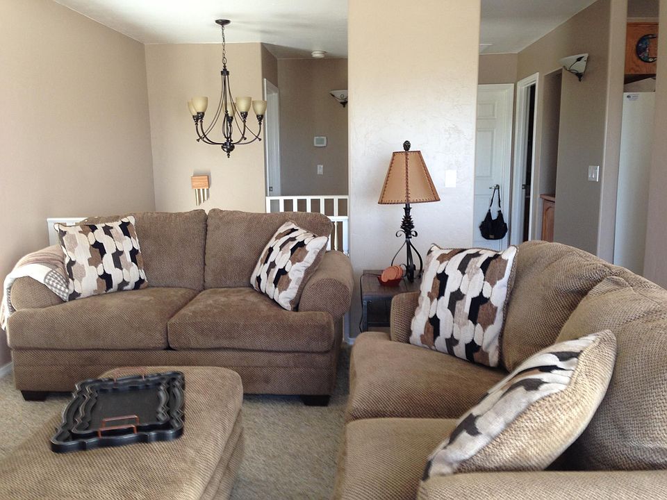 Two love seats and an ottoman in living room.
