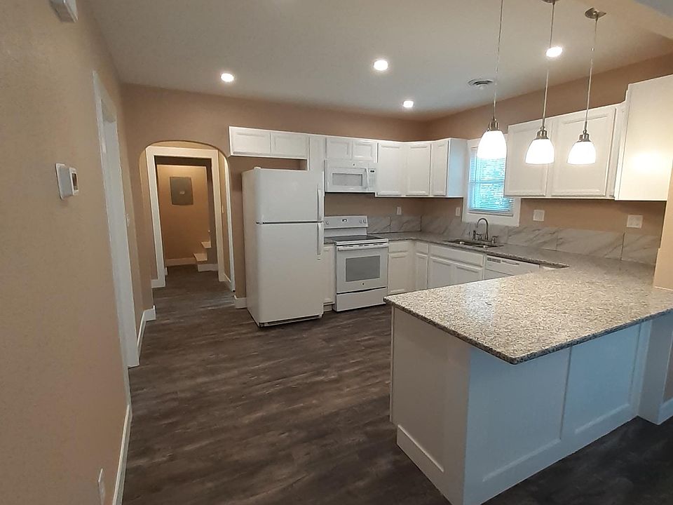Kitchen with granite countertops, tile backsplash, plentiful cabinet space, dishwasher, and new appliances.