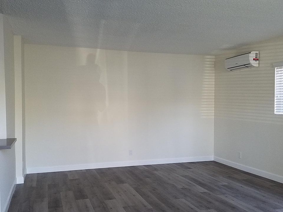 Living room with new plank flooring and wide blinds