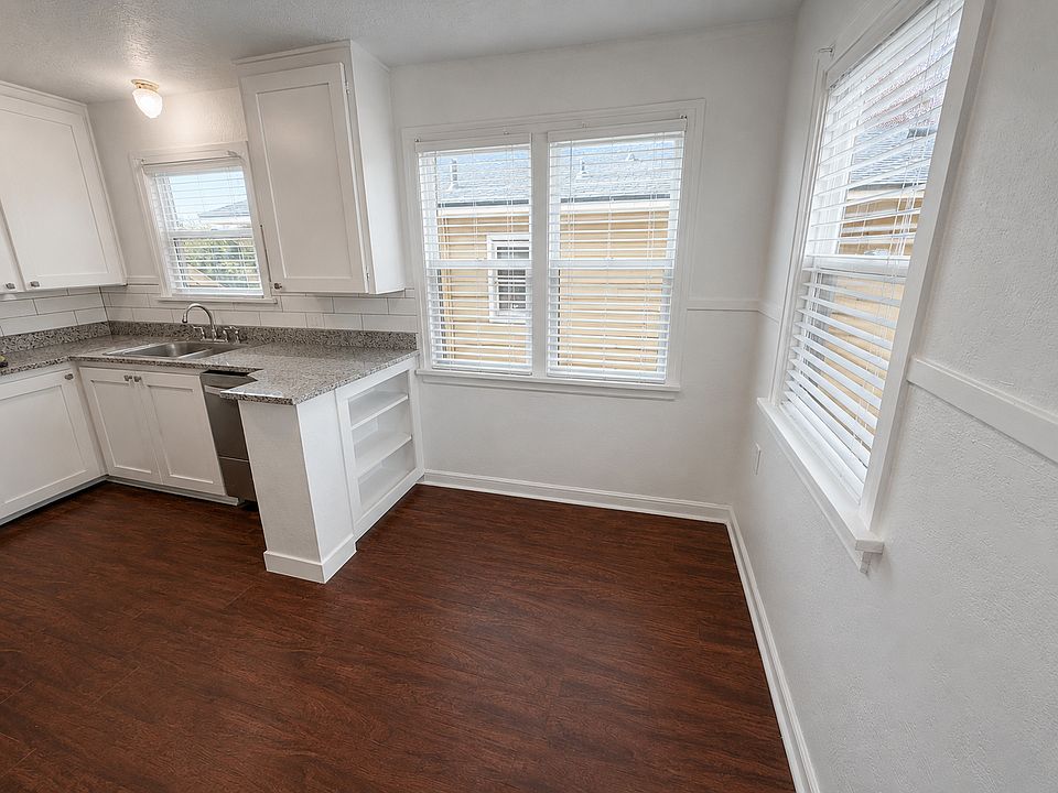 Bright kitchen with granite countertops, stainless steel dishwasher, and plenty of natural light.