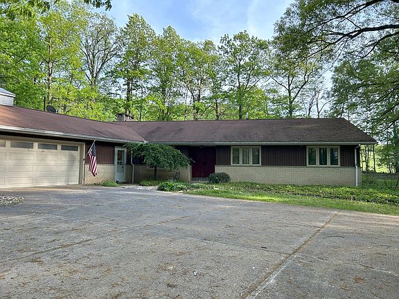 Garage and house. Two entrances available, main front door painted dark red to right of tree and smaller single white door to left of tree and right of garage.