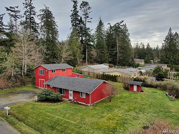 2 Bedrooms, plus Guest Room, HUGE barn/shop and a gardener's dream yard with access to private community beach. This corner lot is spacious and level. 
