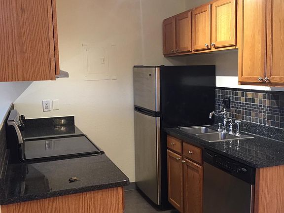 Lots of cabinets in the granite and stainless steel kitchen with tile backsplash.