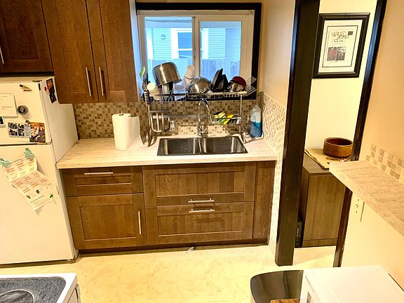 Kitchen with new cabinets, sink, faucet, drainage rack and wall covering