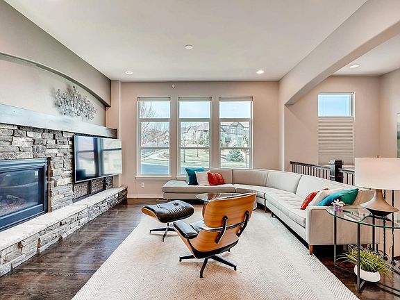 Main floor living room with fireplace, hardwood floors, and large windows.