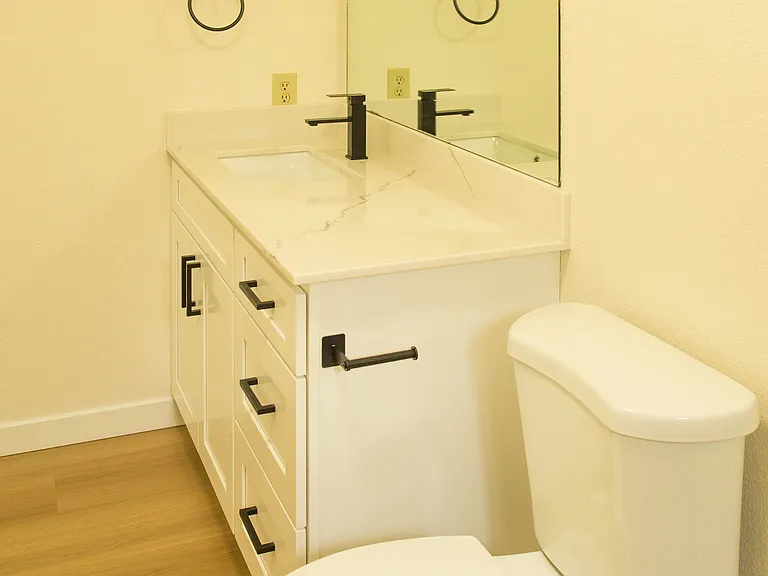 Combined first-floor laundry and half bathroom area with oversized layout, additional storage space, and convenient functional design.