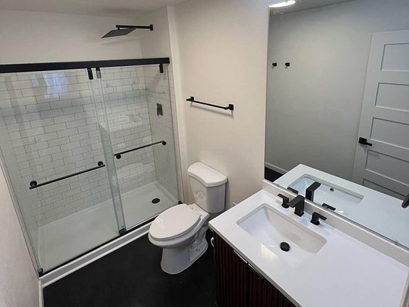 Brand new remodeled bathroom with rain shower, dual sliding glass doors, all new lighting, flooring, toilet, and vanity.