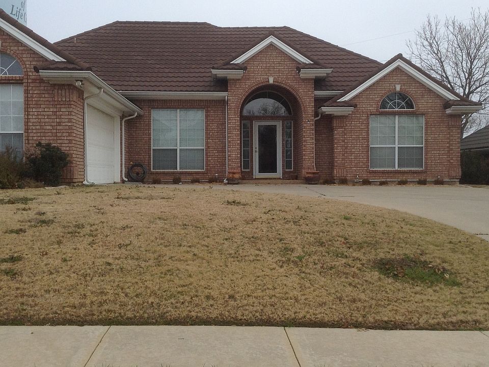 Front of Home with full sprinkler system and gated 8-ft fenc
