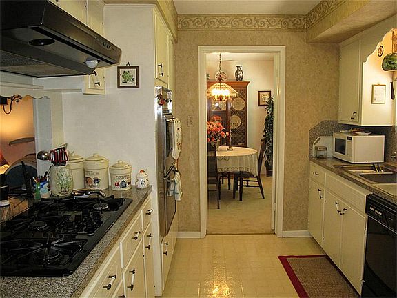 Lovely kitchen boasts updated gas range & updated vent hood, double ovens, abundant cabinetry & counter space, & spacious breakfast bar! Overlooks the family room.