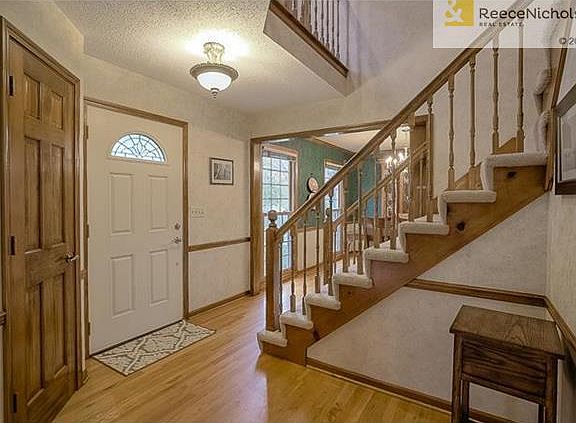 Welcoming entry with updated lighting fixture, hardwoods and coat closet