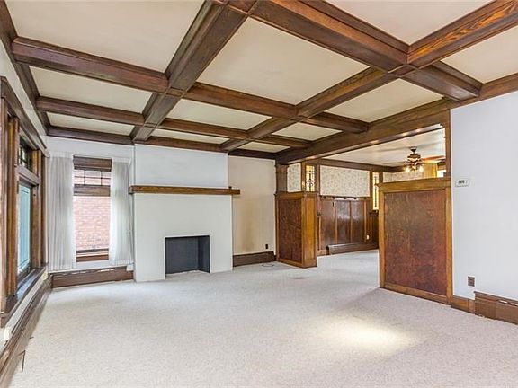 Living room is complete with decorative fireplace and original woodwork