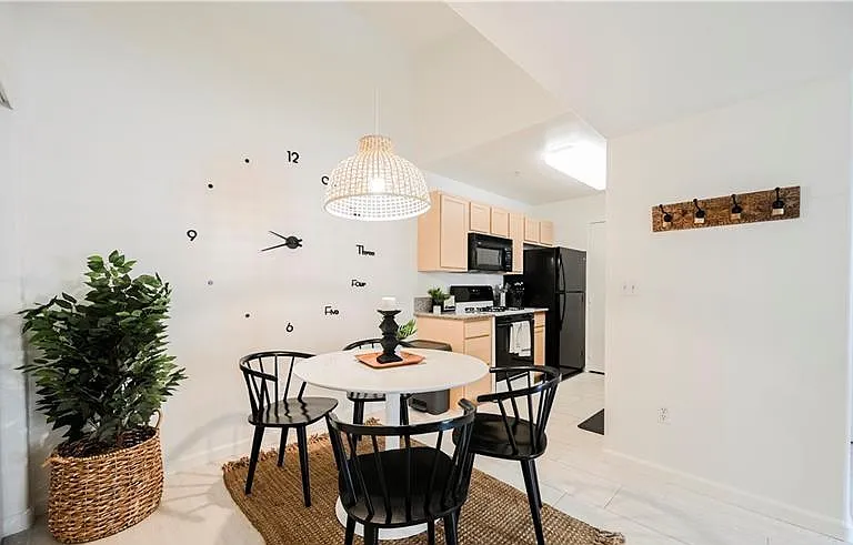 Open dining nook with a round table sits beside the kitchen, offering a convenient setup for daily meals and entertaining.