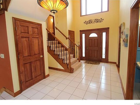 Wide stairwell with new carpet and wrought iron spindles.